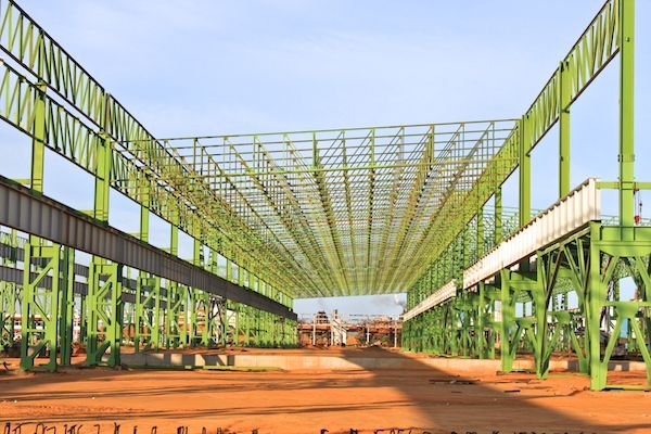 Columnas y vigas verdes de una gran estructura metálica en construcción